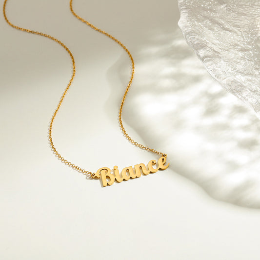 Gold necklace with 'Bianca' pendant on a soft white background