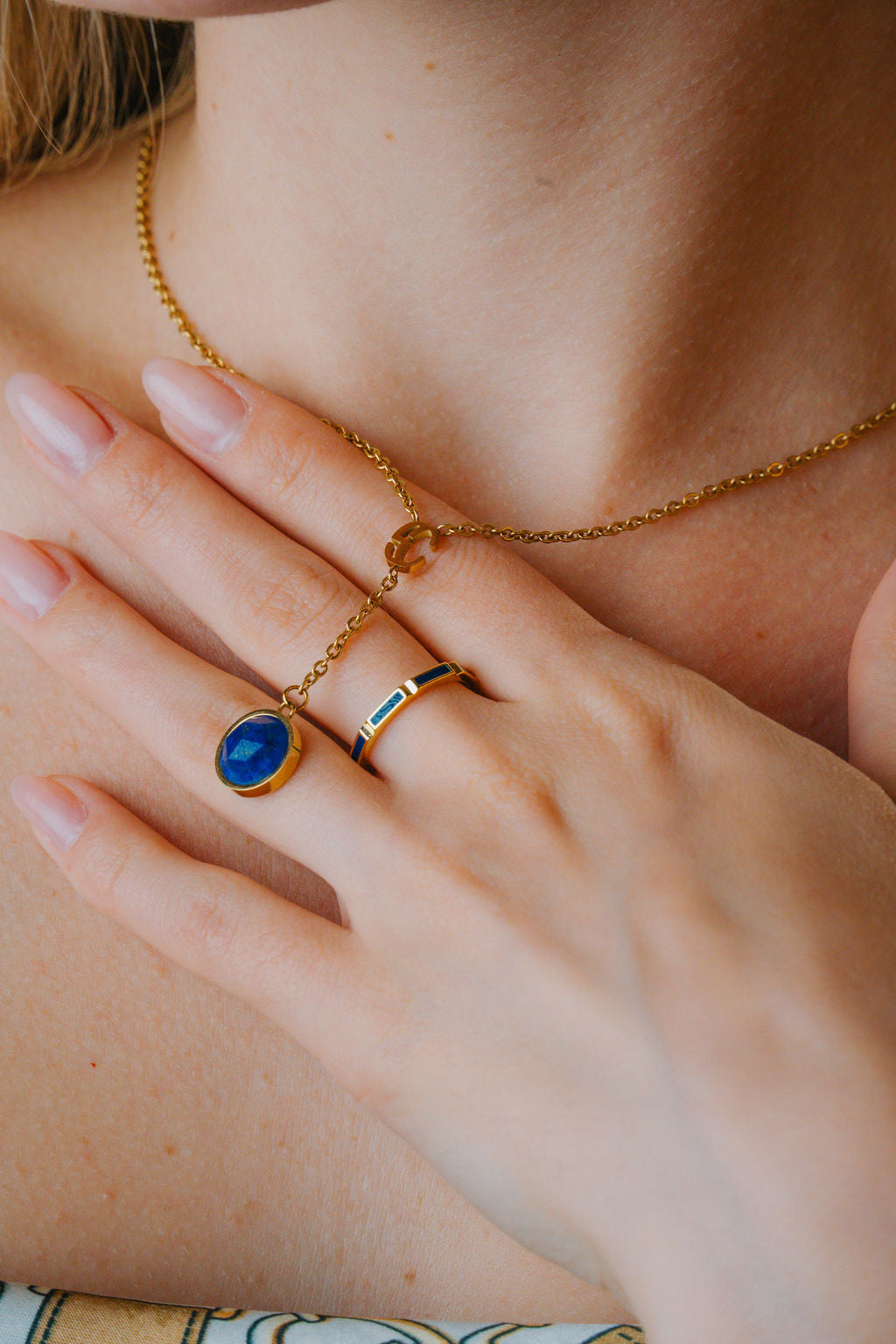 Close-up gold jewelry with a blue gemstone necklace & Enamel Band Ring 925 Sterling Silver 18K Gold on a neutral background
