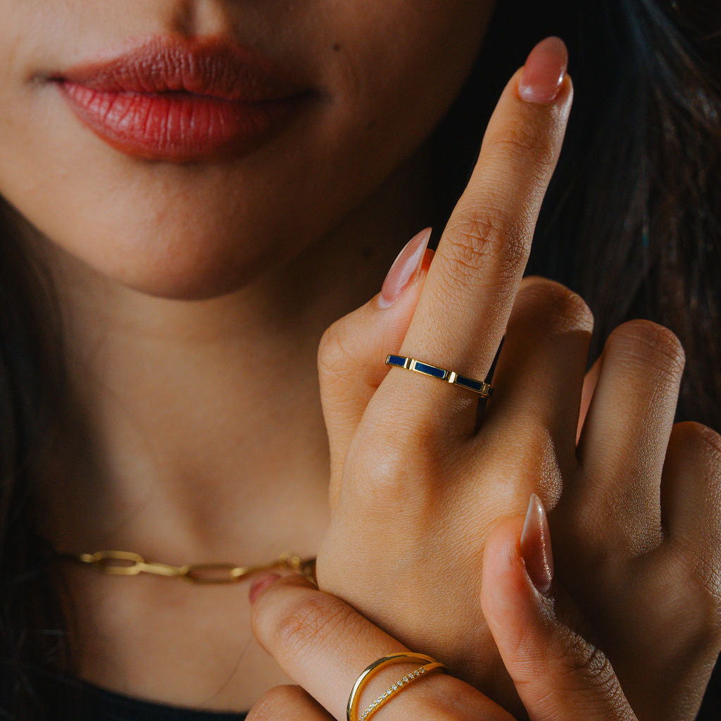 Close-up of a woman's hand with a enamel Band Ring 925 Sterling Silver 18K Gold  and a dark background